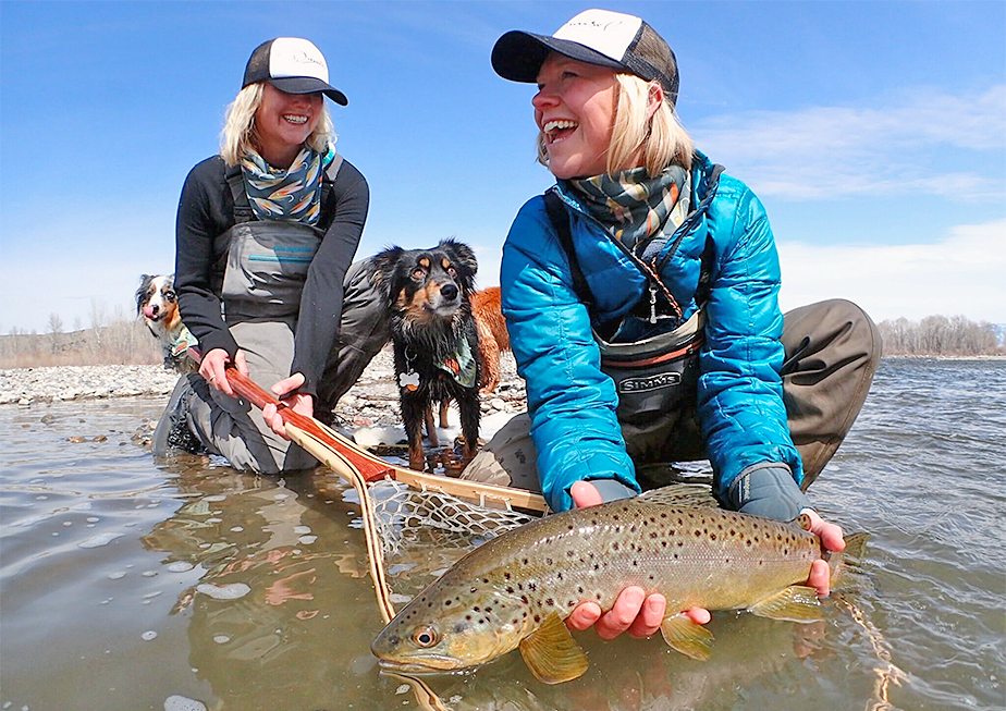 The Tripp sisters wearing snoods while holding a beautiful fish