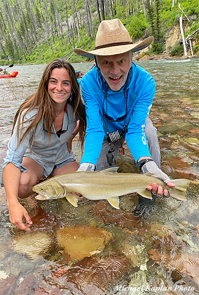 Angler with bull trout and guide Kaitlyn
