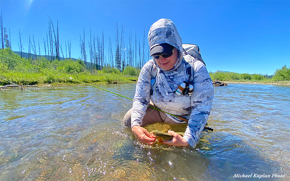 Angler unhooking fly from landed fish