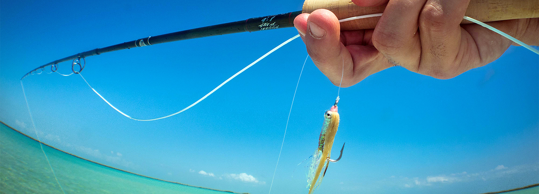 Winston fly rod with a fly hanging in the Bahamas