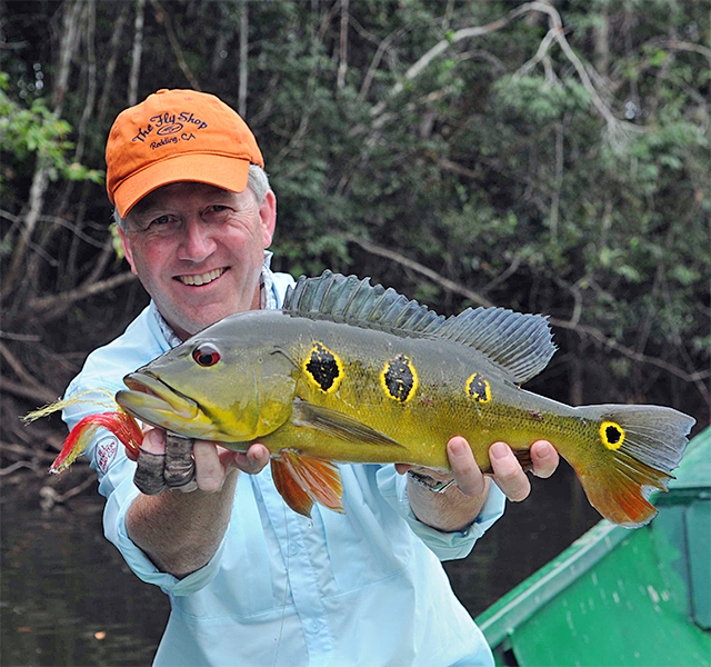 Mike Mercer holding a peacock bass (butterfly) in Colombia