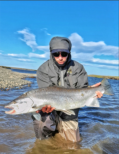 Angler holding a sea-run brown trout at EMB Lodge