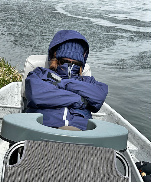 Angler bundled up in the boat to avoid the cold