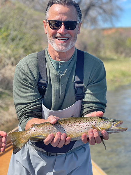 Mike Bertoli holding a brown trout at Kingfisher Lodge