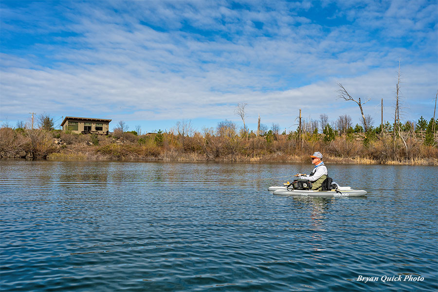 Angler fishing on Rock Creek Lake with the cabin in the background