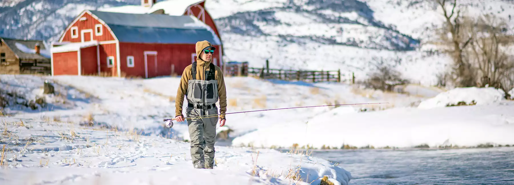 Angler wearing a Skwala Thermo 350 Hoody in the snow in front of a barn