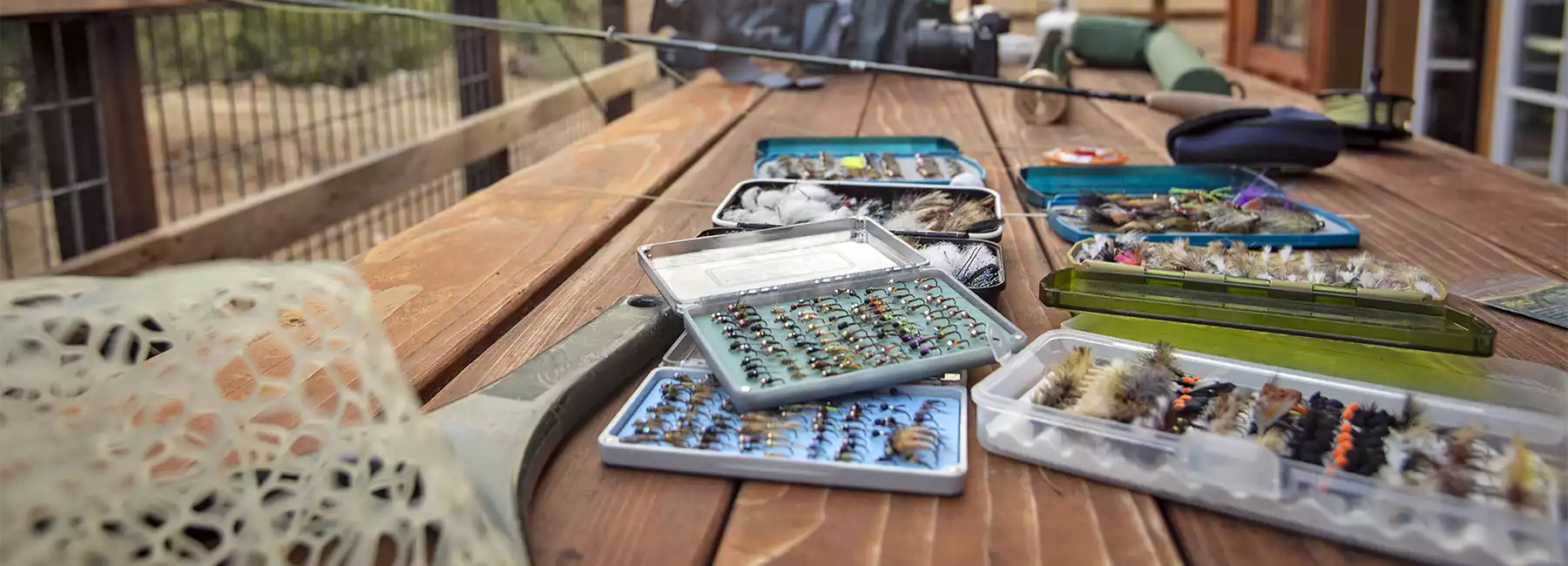 Fly fishing gear laying on a picnic table