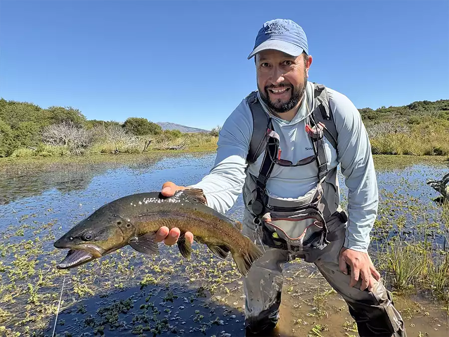 Erik Argotti holding a brown trout at Estancia de Los Rios
