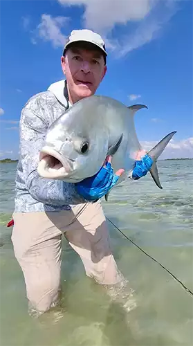 Angler standing in the water holding a permit at ESB Lodge