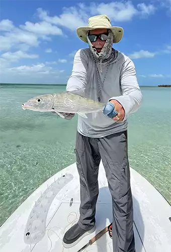 Angler holding a bonefish while standing on a skiff