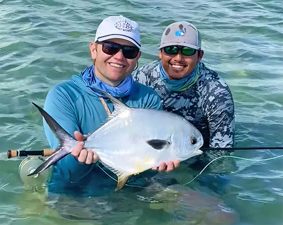 Angler and guide holding a permit in the water at ESB Lodge