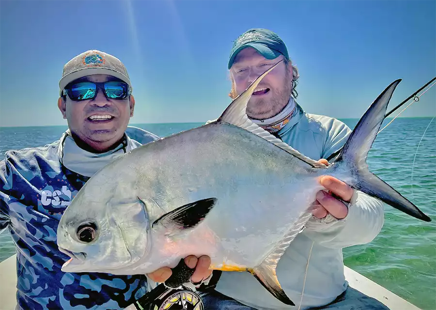 Justin Miller with guide holding a permit at ESB Lodge