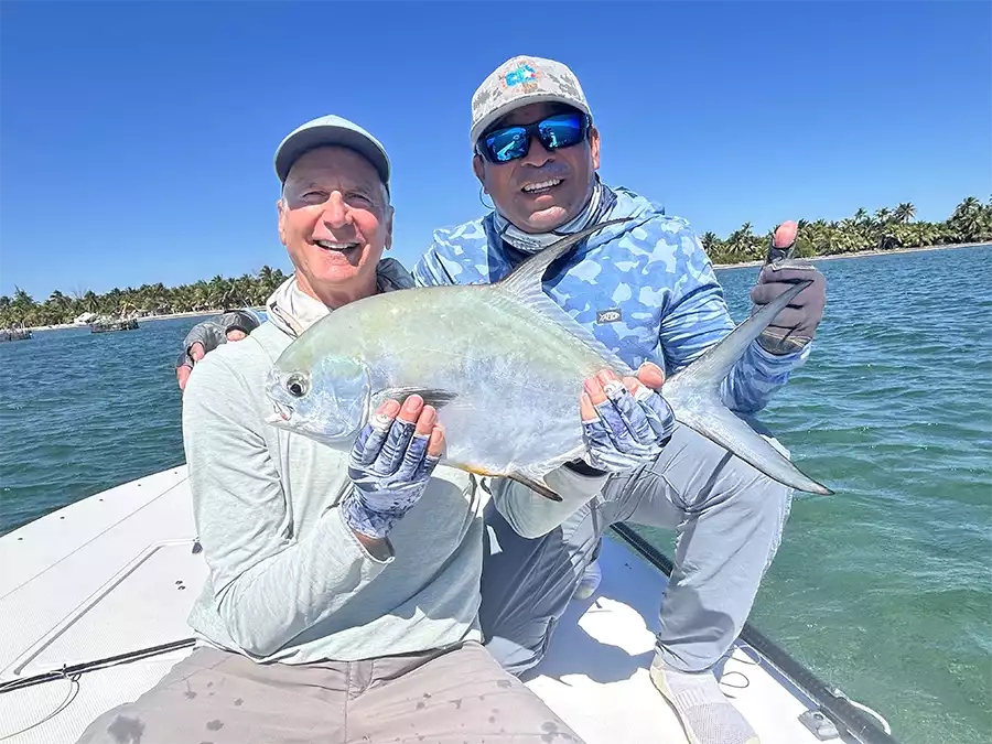 Angler holding a permit with his guide at ESB Lodge