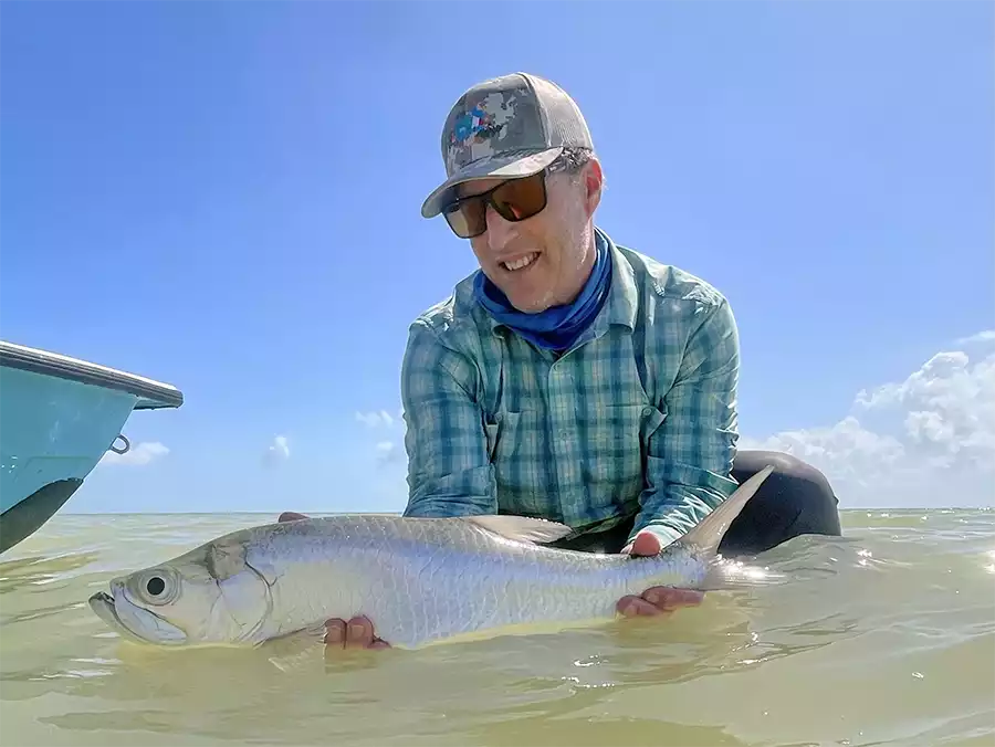 Angler holding a tarpon in the water at ESB Lodge