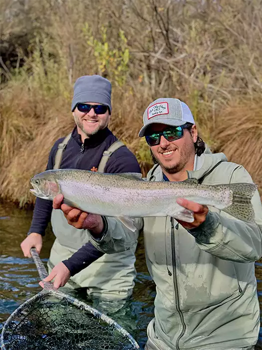 Preston Wedel holding a fish, client holding the net